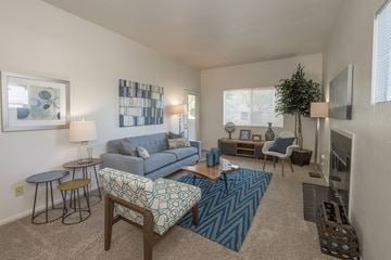 Roseville apartment for rent - A living room with a blue couch and a patterned chair.