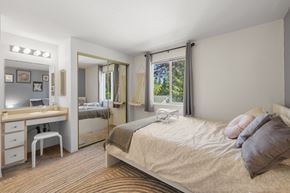 Portland apartment for rent - A bedroom with a bed, vanity, and chair at Clackamas Trails Apartments, Oregon, 97222
