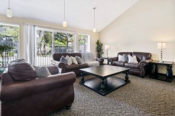 Seatac apartment for rent - A living room with brown leather furniture and a large window.