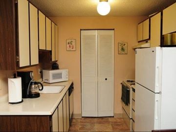 Portland apartment for rent - A kitchen with a white refrigerator, a white sink, and a white coffee maker.