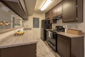 Sacramento apartment for rent - A kitchen with brown cabinets and a black refrigerator.