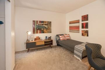 Sacramento apartment for rent - A living room with a grey couch, a chair, a coffee table, and a painting on the wall.