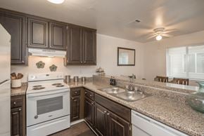 Citrus Heights apartment for rent - A kitchen with a white stove and brown cabinets at Sierra Glen Apartments, California, 95621