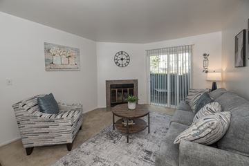 Citrus Heights apartment for rent - A living room with a grey couch, a wooden coffee table, and a painting on the wall.