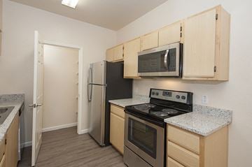 Roseville apartment for rent - a kitchen with stainless steel appliances and wooden cabinets