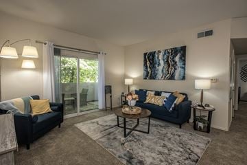 Rocklin apartment for rent - A living room with a blue couch and a painting on the wall.