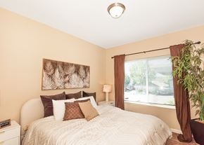 Oregon City townhouse for rent - A bedroom with a large bed and a painting on the wall at The Landing Apartments and Townhomes, Oregon, 97045
