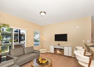Oregon City townhouse for rent - A living room with a grey couch, a coffee table with fruit on it, a fireplace, and a television.