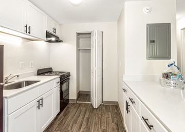 Tualatin apartment for rent - A kitchen with white cabinets and a wooden floor.