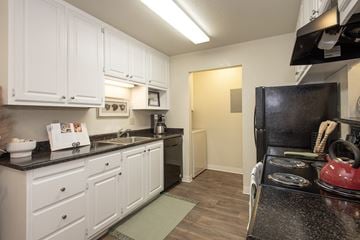 Rancho Cordova apartment for rent - A kitchen with white cabinets and a black stove top.