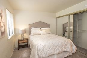 Rancho Cordova apartment for rent - A bedroom with a bed, nightstand, and a mirror at Zinfandel Village Apartments, California, 95670