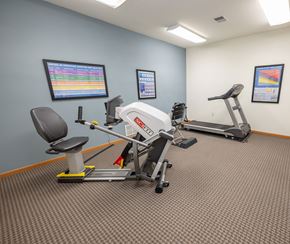 Winneconne apartment for rent - A gym room with a treadmill, exercise bike, and other equipment.