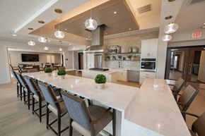 Menomonee Falls townhouse for rent - a large kitchen with a long counter and chairs in front of a table