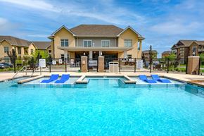 Middleton apartment for rent - a large swimming pool with blue chairs in front of a house