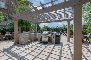 Outdoor patio with fire pit, grilling station, and food preparation area