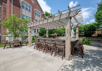 Outdoor patio with fire pit, grilling station, and food preparation area