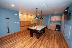 Appleton apartment for rent - A pool table in a room with wooden flooring and a stone wall.