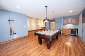 Waukesha apartment for rent - A pool table in a room with wooden floors and a light blue wall.
