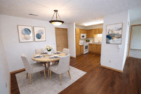 Menomonee Falls apartment for rent - A dining room with a table set for two and a kitchen in the background.