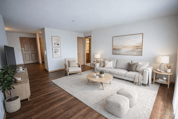 Menomonee Falls apartment for rent - A living room with a white couch, a wooden coffee table, and a painting on the wall.