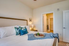 Menomonee Falls townhouse for rent - a bedroom with a large bed with pillows and a basket on it