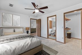 West Allis townhouse for rent - A bedroom with a large bed and a ceiling fan.