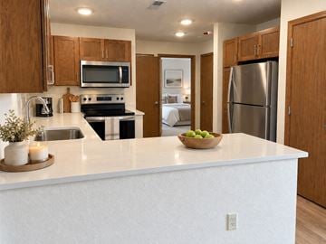 New Berlin apartment for rent - A kitchen with a white countertop and wooden cabinets.