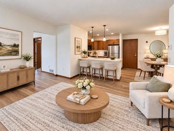 New Berlin apartment for rent - A living room with a coffee table in the center and a dining area in the background.