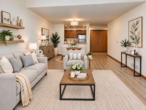 Menomonee Falls apartment for rent - A well-lit, modern living room with a grey sofa, a coffee table, and a dining area in the background.