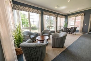 De Pere apartment for rent - A living room with grey striped chairs and a round table.