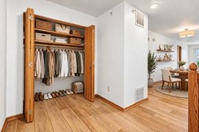 West Allis townhouse for rent - A room with a wooden floor and a white wall with a closet and a chair.