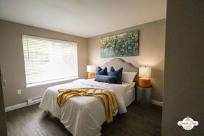 Portland apartment for rent - A bedroom with a white bed and a painting on the wall.