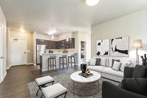 Beaverton apartment for rent - A modern living room with a kitchen in the background.