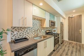 Los Angeles apartment for rent - a kitchen with white cabinets and a sink and a stove