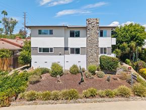 Pasadena apartment for rent - A house with a white and grey exterior and a stone pillar in the front yard.