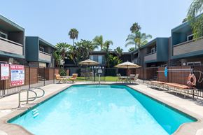 Lemon Grove apartment for rent - A swimming pool surrounded by a fence and chairs.