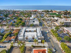 La Jolla apartment for rent - A view of a city with a large building in the center and cars on the road.