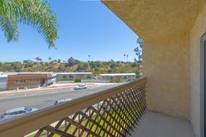San Diego apartment for rent - A balcony view of a building with cars on the street.