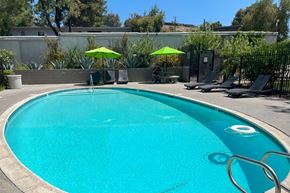 San Diego apartment for rent - a large pool with chairs and umbrellas at a resort