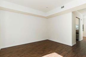 Escondido apartment for rent - Living room with wood style laminate flooring, windows and access to private porch at The Nines Townhomes in Escondido, California.