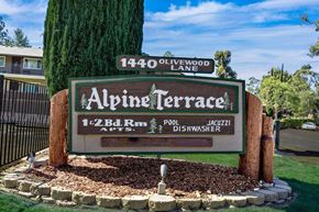 Alpine apartment for rent - A sign for Alpine Terrace with a tree in front of it.