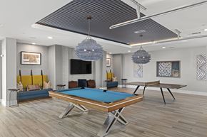 Wilmington apartment for rent - A pool table is in the middle of a room with a TV and a couch.