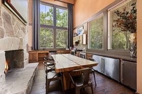 Denton apartment for rent - A dining room with a stone fireplace and a wooden table.