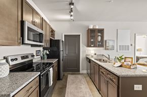 Leland apartment for rent - A kitchen with brown cabinets and a black refrigerator.