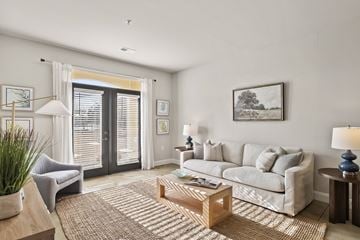 Leland apartment for rent - A living room with a grey couch, a coffee table, and a painting on the wall.