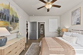Leland apartment for rent - A bedroom with a large bed and a ceiling fan.
