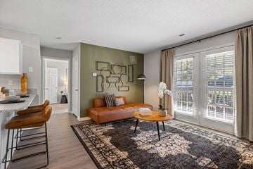 Greensboro apartment for rent - A living room with a brown leather couch and a black and white patterned rug.