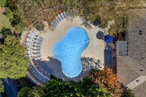 Greensboro apartment for rent - An aerial view of a swimming pool surrounded by trees.