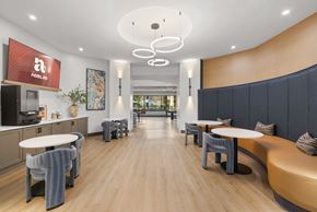 Irving apartment for rent - A modern dining area with wooden floors and a mix of white and dark grey furniture.