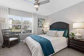 Tampa apartment for rent - A bedroom with a large bed and a ceiling fan.